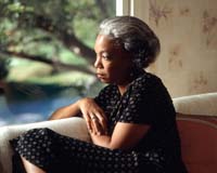 older African-American woman looking out window