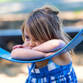 sad little girl rest on swing