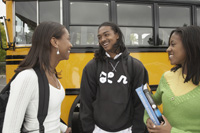 teens talking next to school bus