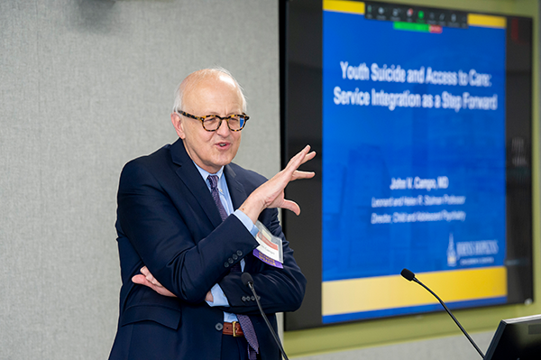 male scientist presenting at a podium