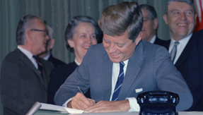 President John F. Kennedy signs the Mental Retardation Facilities and Community Mental Health Center Construction Act.
