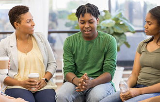 Parent and a teenager talking in a group setting.