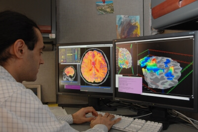 Researcher looking at brain on computer