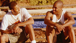 two young men sitting on bleachers talking