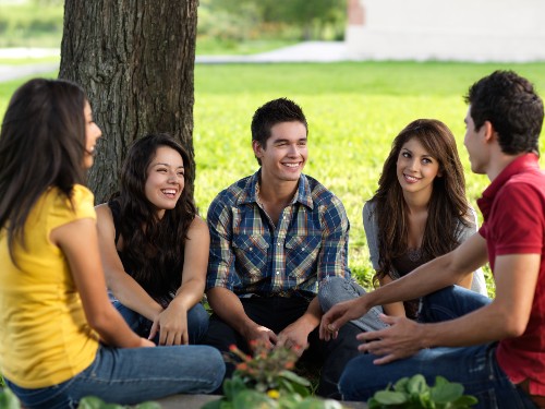 Group of young people hanging out and talking outside.