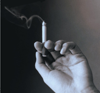 Hand holding lighted cigarette