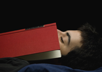 teen boy asleep with book