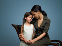 woman holding child while sitting on a chair