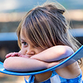 Young child resting against a swing