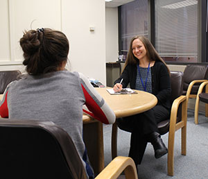 a therapist and patient are seated at a table, talking