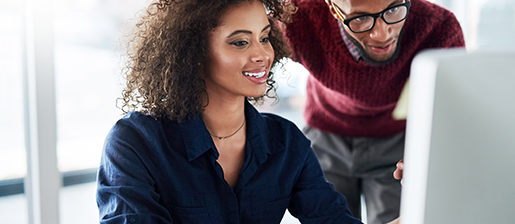 Two coworkers looking at a computer