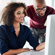 Two coworkers looking at a computer