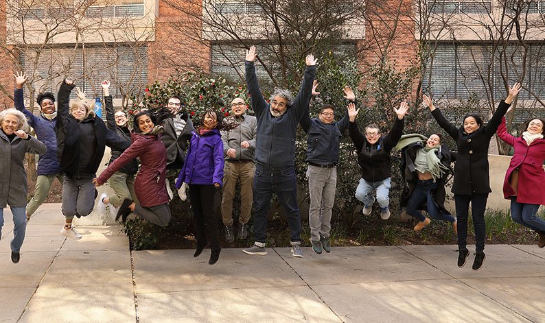 SDN staff posing for a group picture while jumping off the ground