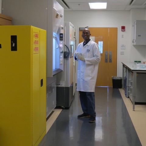 Guru (postdoc) standing in front of the chemical fume hood in the main equipment room, getting ready for histological processing