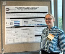 Clara Haeffner smiling in front of her poster at the 2023 Training Day poster session.