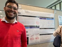 Santiago Guardo-Maya smiling in front of his poster at the 2023 Training Day poster session.