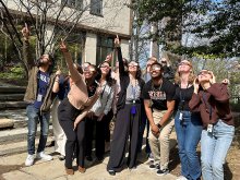 NNT lab members standing outside wearing solar eclipse glasses and viewing the April 8, 2024 eclipse. 